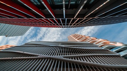 Low-angle shot of two skyscrapers in front of each other covered with windows © Andy-27/Wirestock Creators