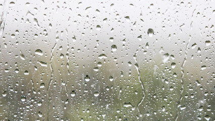 panoramic background - raindrops and trickles of rain close up on window glass in heavy rain