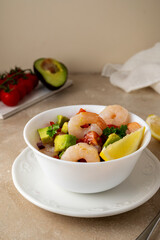 Shrimp cocktail salad with tomatoe, avocado, red onion and lemon.