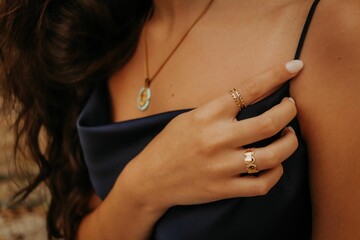 Closeup shot of a woman's hand wearing golden rings