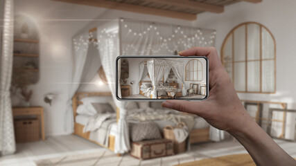 Hand holding smart phone, AR application, simulate furniture and interior design products in real home, architect designer concept, blur background, bohemian bedroom in boho style