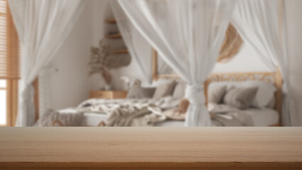Fototapeta na wymiar Empty wooden table, desk or shelf with blurred view of bohemian wooden bedroom in boho style. Canopy bed with pillows, modern interior design concept