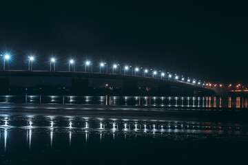 Winter view from the water to the bridge. Night photography. South Bridge, Dnipro city, Ukraine