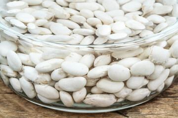 side view bowl of white beans are soaked in water