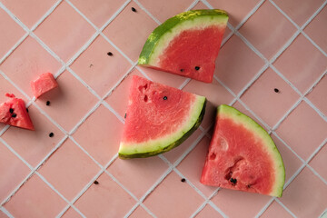 slices of watermelon on a pink table, top view and space for text, fresh and beautiful watermelon