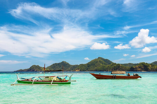 Outrigger canoe and tour boat off Mahoro Island, Pahepa Island beyond, Mahoro, Siau, Sangihe Archipelago, North Sulawesi, Indonesia