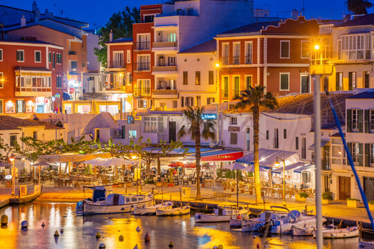 View of cafes, restaurants and boats in harbour at dusk, Cales Fonts, Es Castell, Menorca, Balearic Islands, Spain