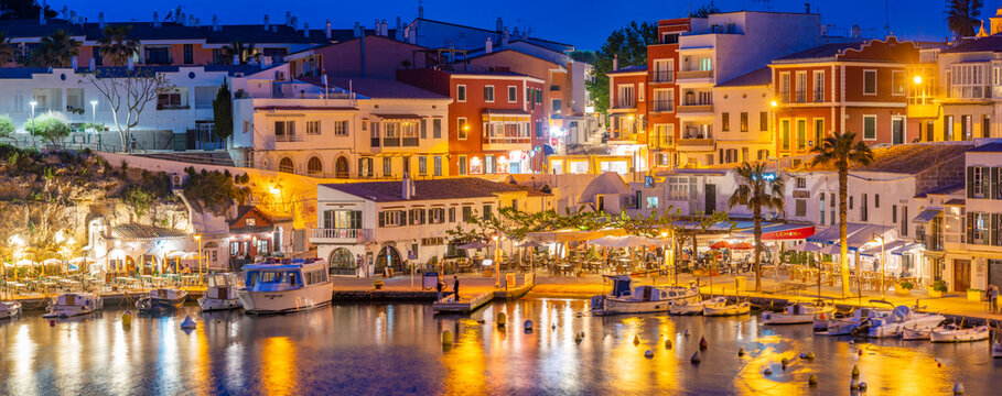 View of cafes, restaurants and boats in harbour at dusk, Cales Fonts, Es Castell, Menorca, Balearic Islands, Spain