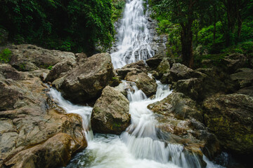 Fototapeta premium Stream waterfall on rocks in the forest. Waterfall stream on rocks. Beautiful waterfall stream. Waterfall stream in forest Thailand