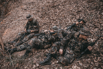 Team of army soldier with machine gun moving in the forest,Thai militia soldier in combat uniforms in the wood,Wander the patrol sloping in the rainforest.