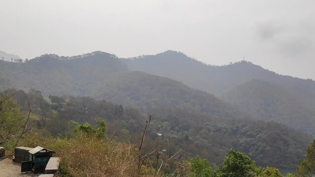 Beautiful view of the Uttarakhand Mountains range, trees and mountains with a foggy sky, India