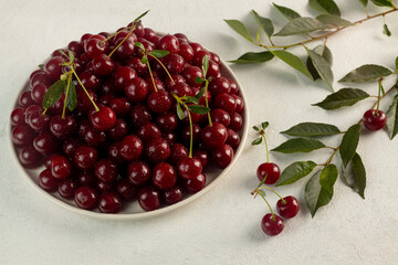 ripe cherries in a plate on a light background