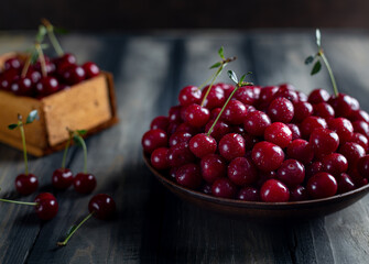ripe cherries in a plate on a wooden table