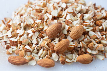 Dry almond and almond slice on white cut board.