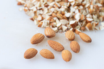 Dry almond and almond slice on white cut board.