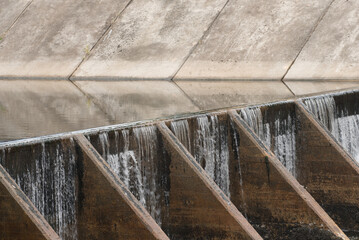 The water flow pass the weir from upper level to lower level.Water flow very fast in rainy season.Selective focus.