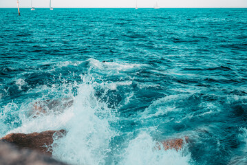 Close-up of water splashes against the breakwaters on the Balearic Sea. View from the pier on the...