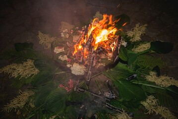 Camp bonfire with flowers during Latvian wedding ritual