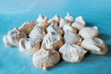 Homemade french milk-colored meringues on blue paper