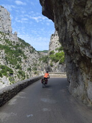 jeune femme à vélo sur les routes dans les Corbières de l'Aude sud de France gorges de galamus