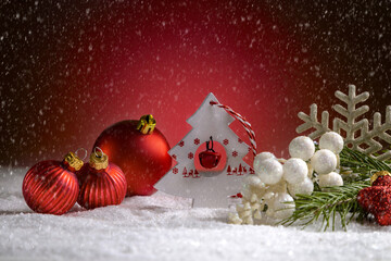 Christmas decorations and fir branches on a red Christmas background.