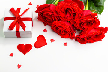 Gift box, rose flowers and decorative hearts on a white background