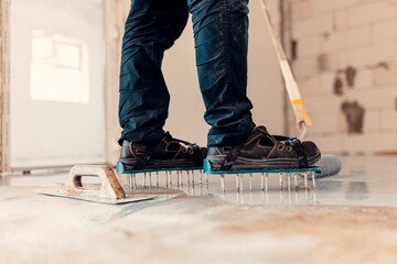 Closeup shot of a worker applying grey epoxy resin on the floor