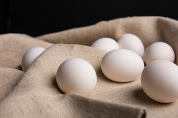 Chicken white eggs on burlap. Farm products. Natural eggs. Chicken eggs on the table.