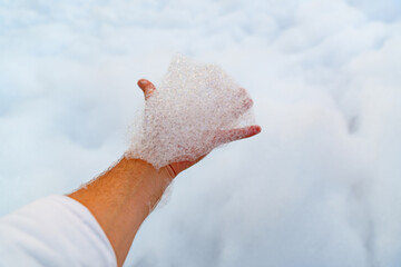 male hand with white foam for foam party. background and texture.