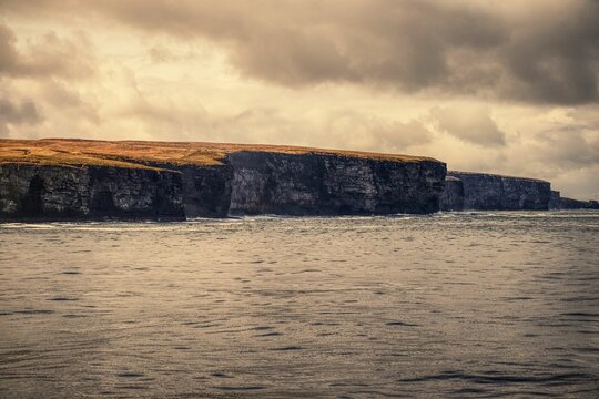 Beautiful view of big cliffs at the North Coast on a cloudy day in Scrabster, Scotland