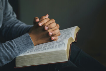 Man praying hands clasped together on  Bible. Christian life crisis prayer to god. Man Pray for god...