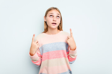 Young caucasian girl isolated on blue background pointing upside with opened mouth.