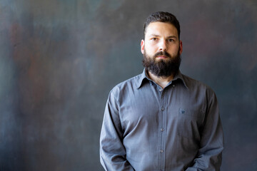 A young man with a beard on a gray background