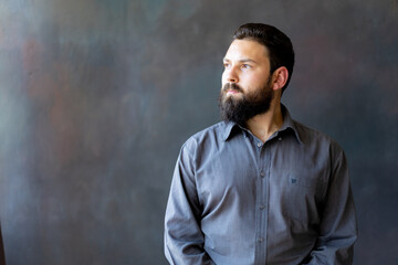 A young man with a beard on a gray background