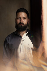 Attractive young man with a beard in a shirt