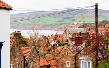 Beautiful view of Robin Hood's Bay cottages against green mountains in England