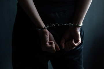 male hands in handcuffs black background