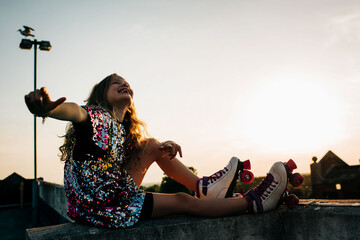 girl blissfully happy roller booting and dancing at sunset