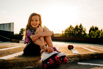 portrait of a young girl in her roller boots happy at sunset