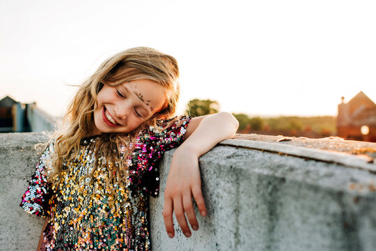 portrait of a young girl smiling in a sequin dress at sunset