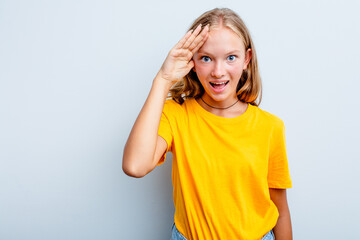 Caucasian teen girl isolated on blue background shouts loud, keeps eyes opened and hands tense.