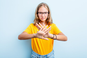 Caucasian teen girl isolated on blue background standing with outstretched hand showing stop sign, preventing you.