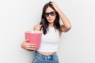 Young caucasian woman eating popcorn isolated on white background being shocked, she has remembered important meeting.