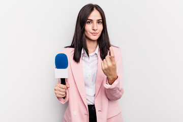 Fototapeta premium Young TV presenter caucasian woman isolated on white background pointing with finger at you as if inviting come closer.