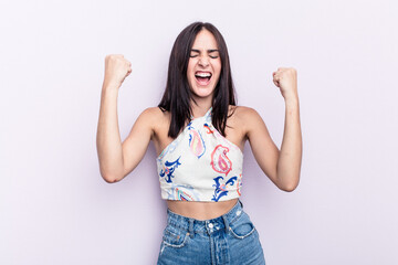 Young caucasian woman isolated on pink background cheering carefree and excited. Victory concept.