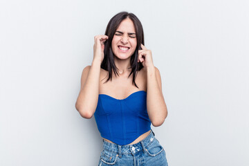 Young caucasian woman isolated on white background covering ears with hands.