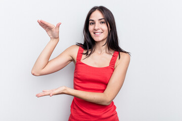 Young caucasian woman isolated on white background holding something little with forefingers, smiling and confident.