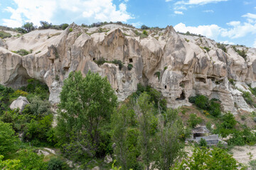 Landscape of Goreme, in Cappadocia, with the typical rocks there on a sunny day with some clouds.