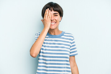 Young caucasian woman with a short hair cut isolated having fun covering half of face with palm.