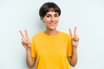 Young caucasian woman with a short hair cut isolated showing victory sign and smiling broadly.